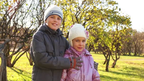 Niño con chica en el parque de otoño — Vídeos de Stock