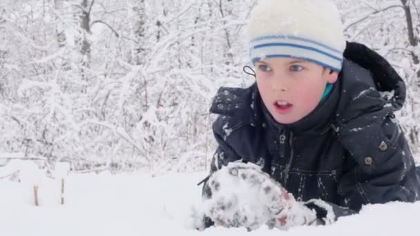 Ung pojke gör snöboll och kast — Stockvideo