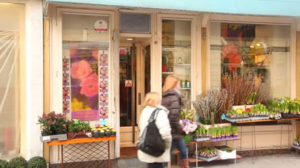 As pessoas passam por pequena loja de flores — Vídeo de Stock