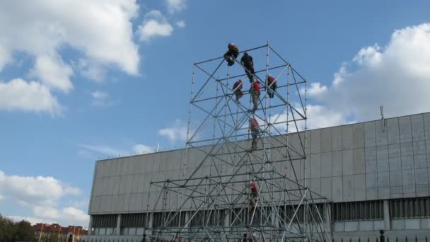 Team van werknemers bouwen toren — Stockvideo