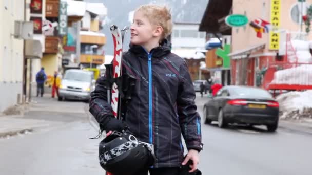 Teenager s lyžemi stojí na ulici — Stock video