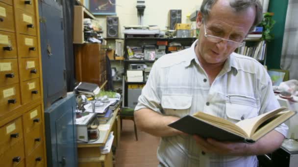 Mann liest Buch im Labor — Stockvideo