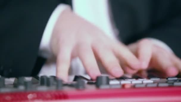 Muž v obleku hraje na digitální piano — Stock video