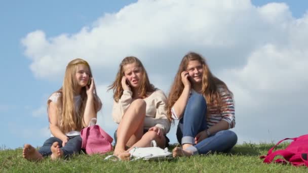 Três meninas falam em telefones celulares — Vídeo de Stock