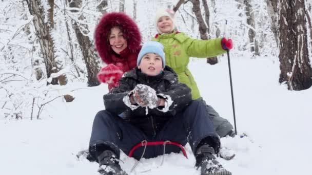 Mother sings on sled with children — Stock Video