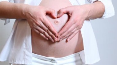 Hamile kadın kalp işareti yapar
