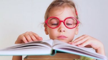 Küçük kız kitap okuyor.