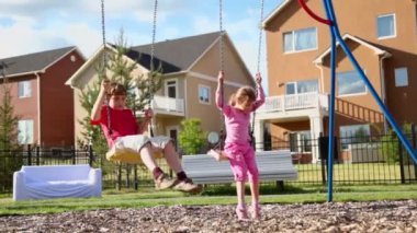 Erkek ve kız salıncağa sway