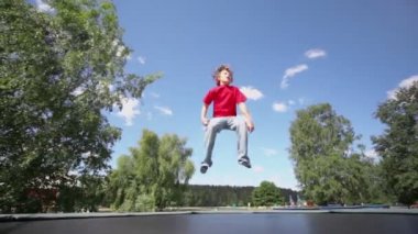 Küçük çocuk trambolin üzerinde atlar