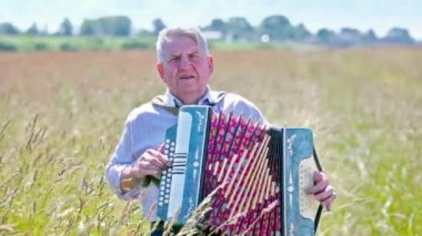 Yaşlı adam akordeon çalar