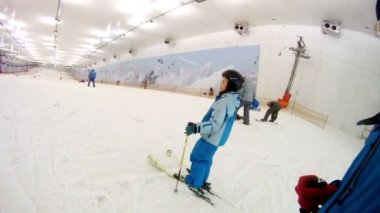 Çocuk kayaklar üzerinde aşağı taşır