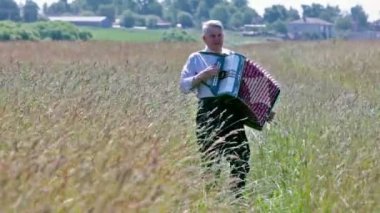 Yaşlı adam akordeon çalar