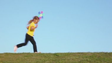 Küçük kız yel değirmeni oyuncak tutar ve çalışır