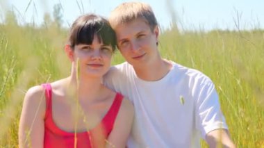 Kız ve adam otların arasında oturmak