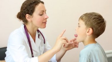 Kadın doktor dil ve gözleri inceliyor