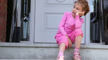 Küçük kız verandada oturuyor