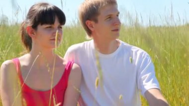 Kız ve adam otların arasında oturmak