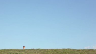 Çocuk çim tepenin arkasından kız yaklaşımla