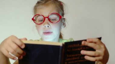 Küçük kız kitap okuyor.