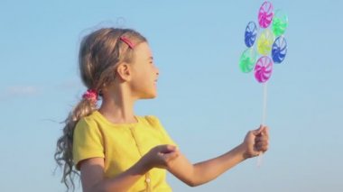 Küçük kız yel değirmeni oyuncakla oynar