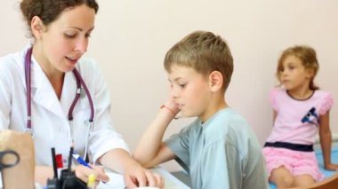 Kadın doktor çocuğun boğazını inceliyor