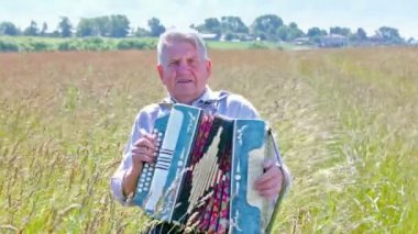 Yaşlı adam akordeon çalar