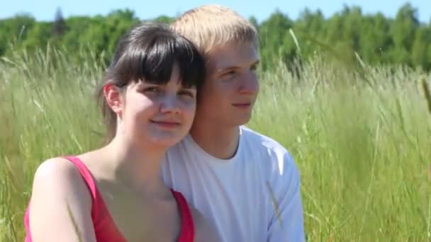 Chica y chico sentarse en la hierba — Vídeos de Stock