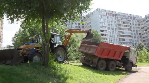 Трактор завантажує землю в вантажівку — стокове відео