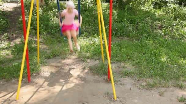 Girl on color children swing — Stock Video