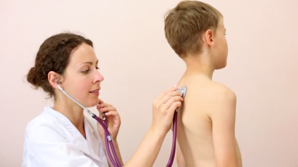 少年の背中に耳を傾ける医師 — ストック動画