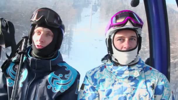 Zwei Skifahrer fahren mit Standseilbahn — Stockvideo