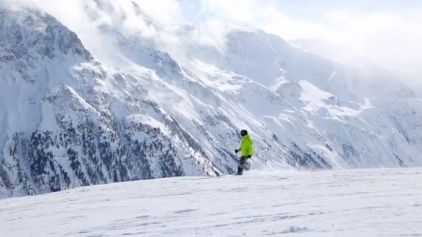 Skiër draait op heuvel en naar beneden gaat — Stockvideo