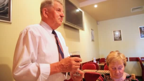 Elderly man holds glass and says — Stock Video