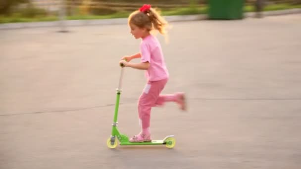 Meisje rijdt groene scooter — Stockvideo