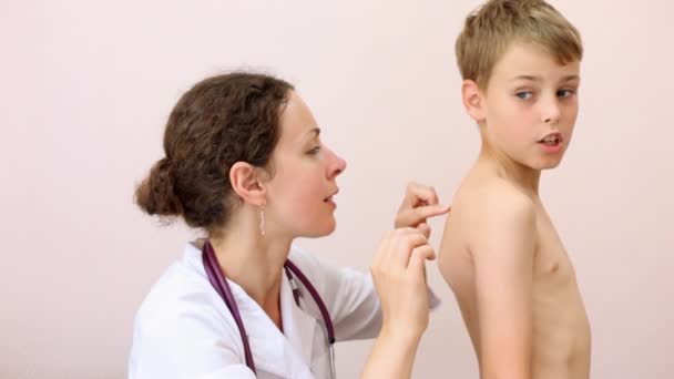 Woman doctor inspecting back of boy — Stock Video