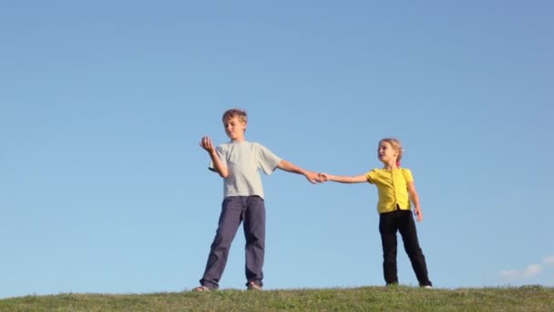 Boy with girl hold hands on grass — Stock Video