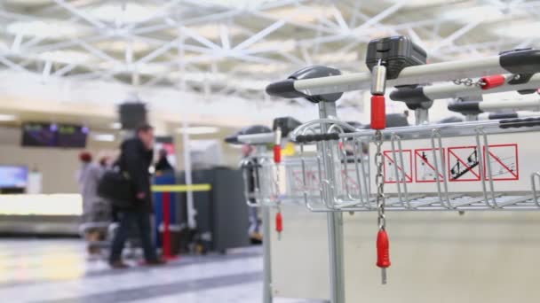 Chaîne sur chariot à bagages à l'aéroport et les passagers — Video