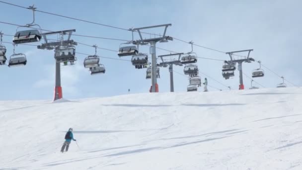 Mensen rijden ski in de buurt van kabelbaan — Stockvideo