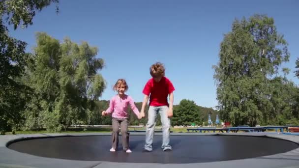 Boy with girl jump on trampoline — Stock Video