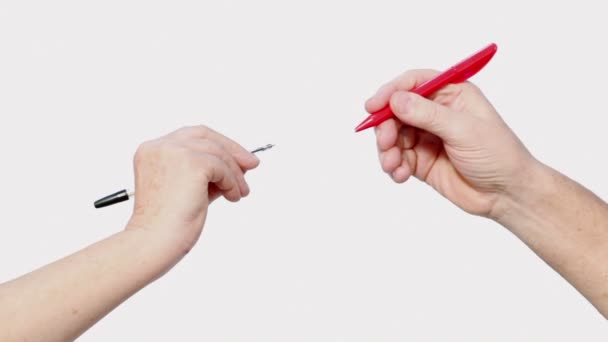 Deux mains seniors tiennent des stylos — Video