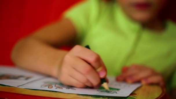 Маленькая девочка рисует на бумаге — стоковое видео