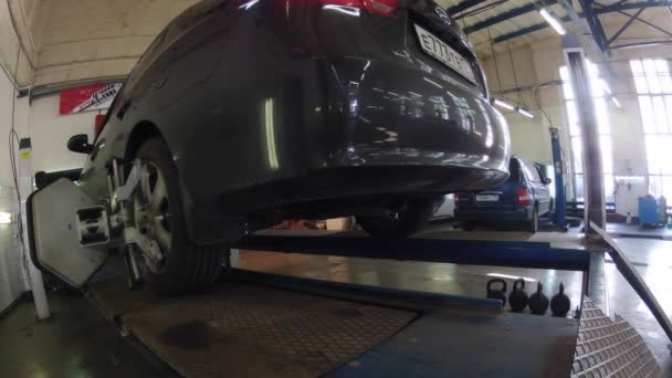 Mecánico de coches hace diagnósticos de alineación de ruedas — Vídeo de stock