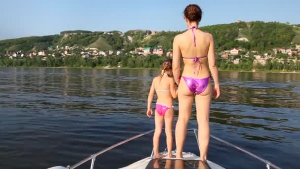 Mother with daughter stand on nose of boat — Stock Video