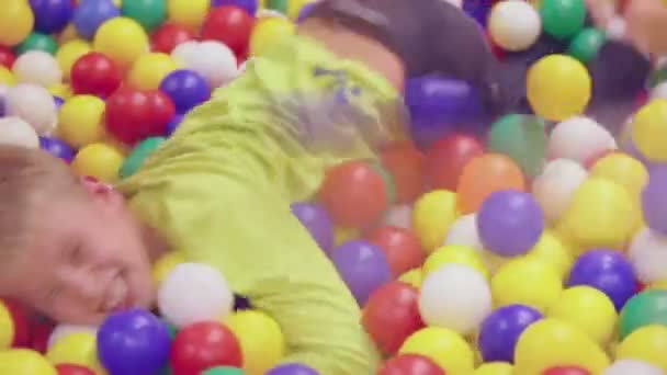 Young boy in colorful plastic spheres — Stock Video