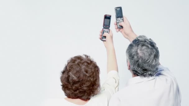 Casal velho apertar botões em celulares — Vídeo de Stock