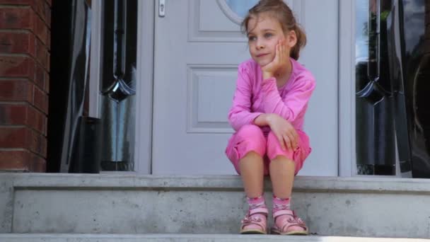 Liten flicka sitter på verandan — Stockvideo