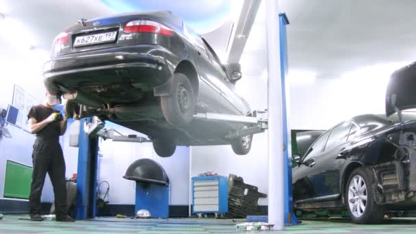 Meccanico di lavoro con pneumatico auto — Video Stock