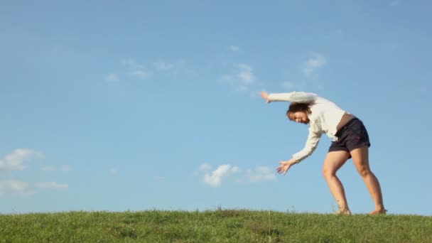 Дівчина катається на пагорбі трави — стокове відео
