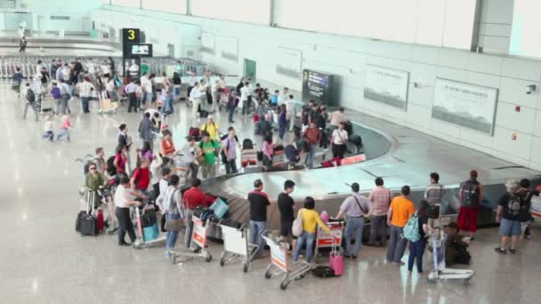 Passagiers wachten op hun bagage — Stockvideo