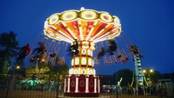 Mensen vliegen op ronde draaiingen carrousel — Stockvideo